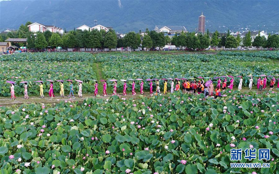 旗袍爱好者在四川省绵竹市九龙镇新龙村荷塘参加旗袍走秀