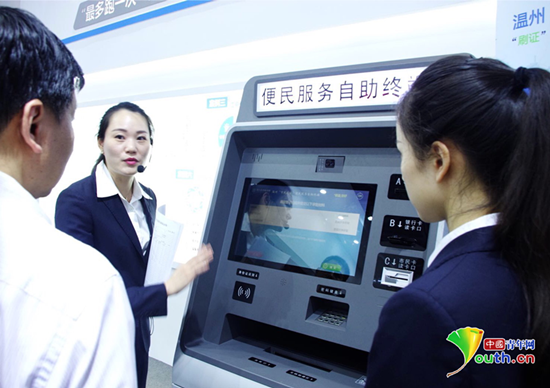 首届数字中国建设成果展览会上，在电子政务展区浙江展台前，工作人员正在向观众讲解便民服务自助终端的使用方法。10类101个服务事项可以通过这台机器来办理。中国青年网记者 张潼 摄