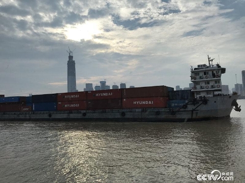 一艘满载集装箱的货轮沿江而下(孔华/摄)