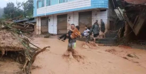 麻栗坡县猛硐乡9.02特大山洪泥石流灾害发生后,官兵搜救转移群众。中间抱着穿白衣服小男孩的就是杜富国。(陈杨 图)