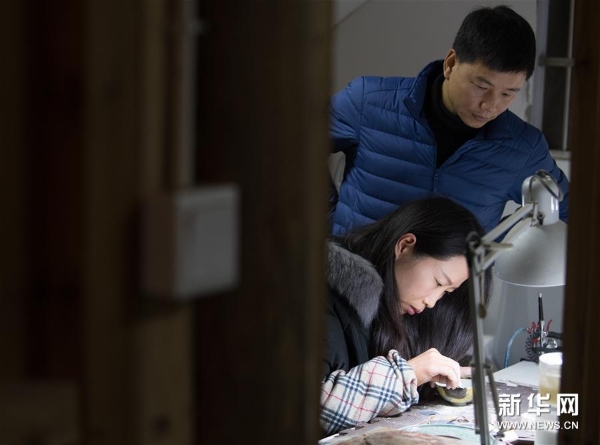 吴荣强和妻子李淑敏在龙泉市牛头岭村“七分醉”工作室对一件漆缮器皿进行打磨