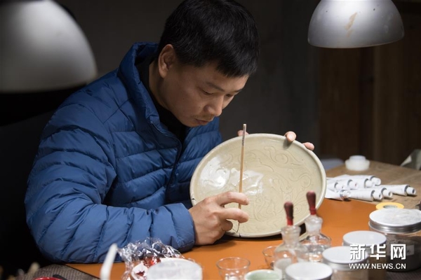 吴荣强在龙泉市牛头岭村“七分醉”工作室对一件青瓷器皿进行漆缮