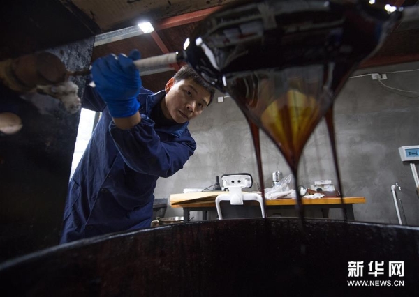 吴荣强在龙泉市牛头岭村“七分醉”工作室滤漆