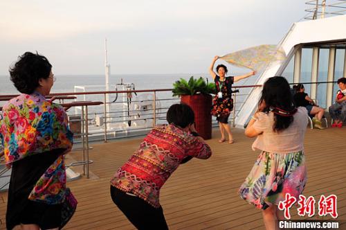 资料图片:游客在邮轮甲板上拍照留念。<a target='_blank' href='http://www.chinanews.com/'>中新社</a>记者 蔡红文 摄 点击进入下一页