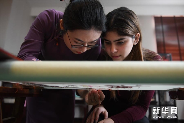 3月14日，在位于苏州吴中区光福镇的向红绣府刺绣艺术工作室，府涵璐在指导巴拿马留学生玛利娅刺绣。