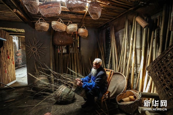 3月20日，72岁的罗朝荣在彭镇老街的竹编坊内编竹篓。他从18岁开始学艺，为了传承竹编手艺还带了很多徒弟。 彭镇老街位于四川省成都市双流区，这里的灰瓦白墙砖木结构建筑，像是老照相馆里的黑白相片，将记忆和岁月定格。
