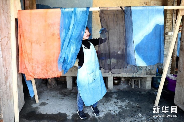 3月20日，工作人员在彭镇老街晾晒染好的织物。 彭镇老街位于四川省成都市双流区，这里的灰瓦白墙砖木结构建筑，像是老照相馆里的黑白相片，将记忆和岁月定格。 新华社记者张玉薇摄