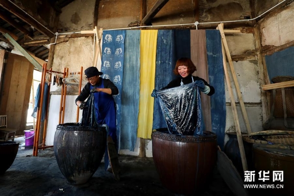 3月20日，工作人员在彭镇老街展示手工染布。 彭镇老街位于四川省成都市双流区，这里的灰瓦白墙砖木结构建筑，像是老照相馆里的黑白相片，将记忆和岁月定格。 新华社记者张玉薇摄