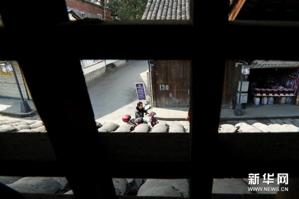 3月20日，居民骑车驶过彭镇老街。 彭镇老街位于四川省成都市双流区，这里的灰瓦白墙砖木结构建筑，像是老照相馆里的黑白相片，将记忆和岁月定格。 新华社记者张玉薇摄