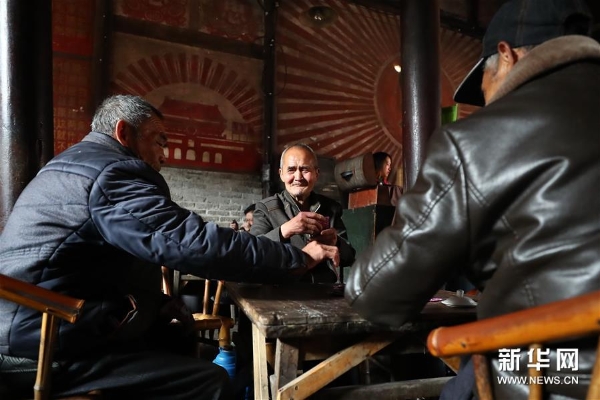 3月20日，老茶客们在彭镇老茶馆内喝茶打牌。彭镇老茶馆又称观音阁老茶馆，距今有100多年历史，已成为彭镇老街的一张名片。 彭镇老街位于四川省成都市双流区，这里的灰瓦白墙砖木结构建筑，像是老照相馆里的黑白相片，将记忆和岁月定格。 新华社记者张玉薇摄