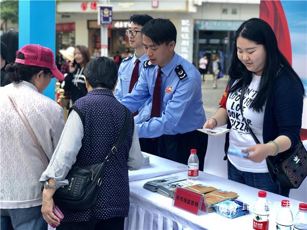 多部门相关人员向市民发放诚信宣传手册。记者上官艳君摄