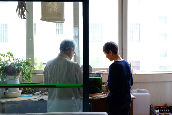 钟远财和妻子陶瑜在阳台喂鱼。记者曹月 摄