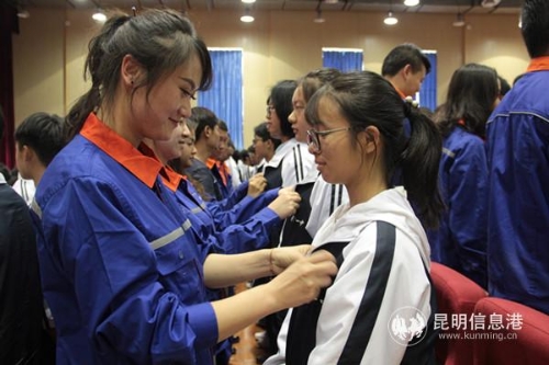 老团员为新团员佩戴团徽。供图