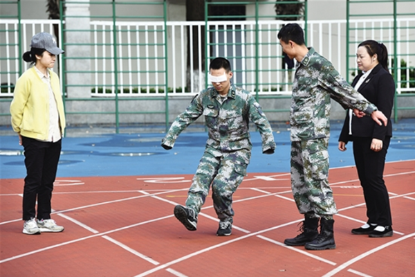 在陆军军医大学操场上，杜富国在家人和战友的陪伴下进行下肢力量康复训练。