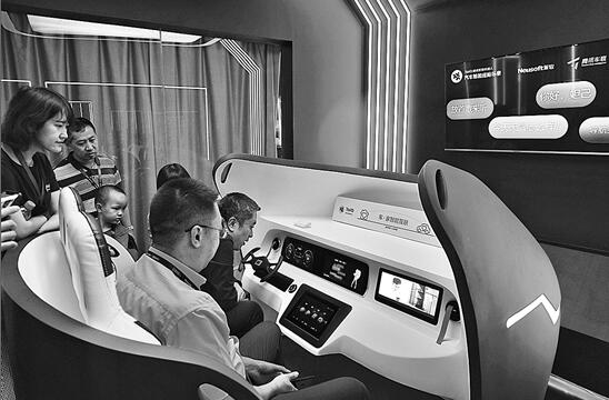 在昆明滇池国际会展中心，参展人员体验车载及家用智能产品。 新华社记者 秦晴 摄