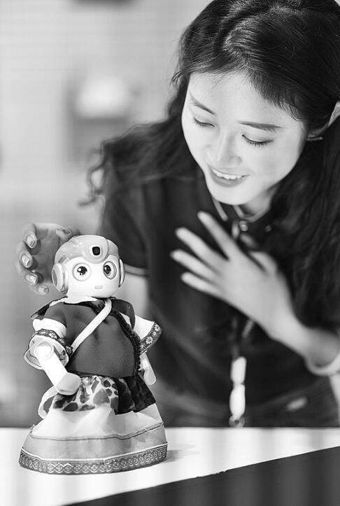 参展企业工作人员与“悟空机器人”互动。 新华社记者 秦晴 摄