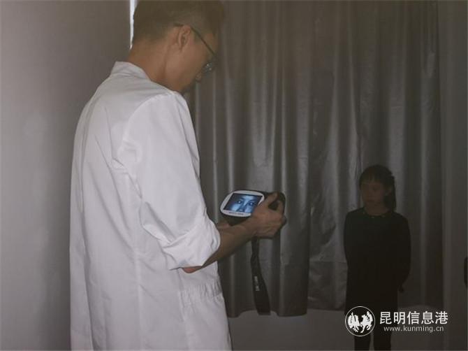 医生手持智能检测仪为孩子检测视力。