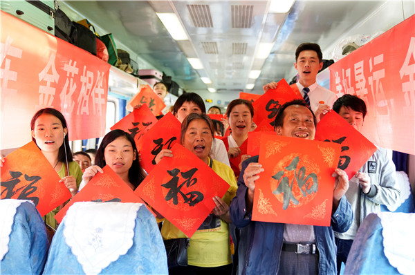 7月18日，在昆明开往攀枝花的6162次慢火车上，乘务员为旅客送福，祝福沿线乘车民众生活幸福美满。