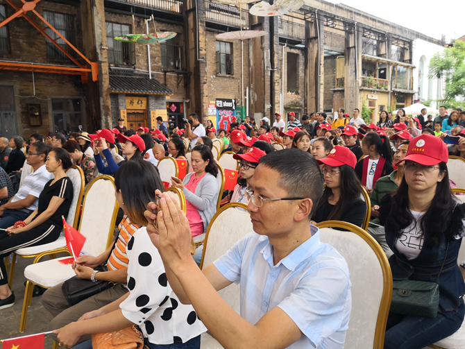 社区群众纷纷举起手机拍摄开幕式节目。