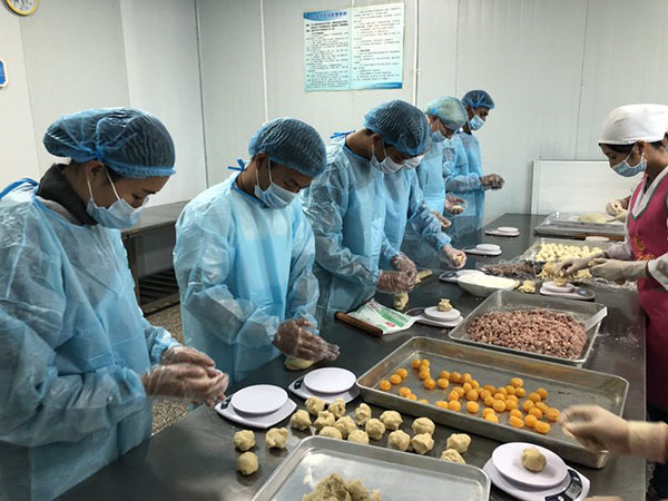 4 外国友人们在烘焙师傅的指导下有模有样地制作月饼。 记者苏雯芊 摄