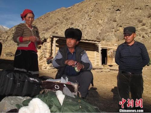 图为居马泰·俄白克(中)在包扎墩牧区牧民发放药品。 图为居马泰·俄白克(中)在包扎墩牧区牧民发放药品。