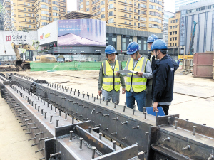 朱川东带着几个徒弟仔细检查钢立柱各项指标是否合格。 记者黄晓松摄