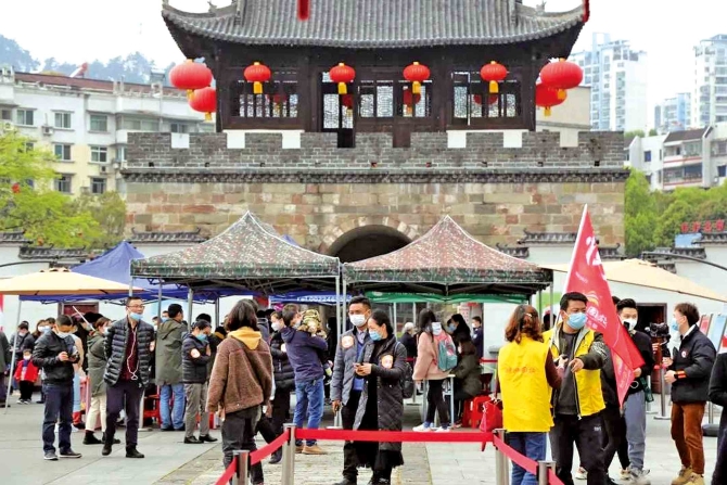 图为景区入口处，游客等待安检。