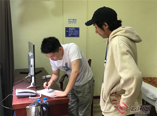 贡山县文旅局工作人员(左一)到宾馆核实滞留游客住宿情况.png