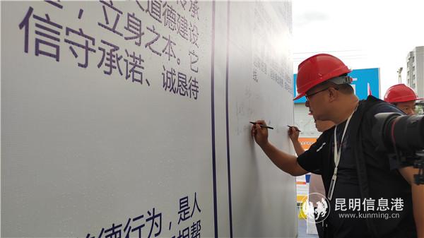 活动现场，参与者在安全承诺签名墙上签字。