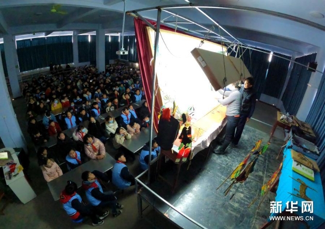 12月15日，在位于河南省许昌市建安区苏桥镇的河南省润知非物质文化遗产研学旅行基地，许昌陈氏皮影第四代传人陈志国和徒弟一起为学生演出皮影戏《武松打虎》。新华社发（牛书培 摄）