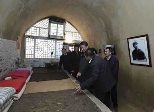 这是13日上午，习近平在延安市延川县文安驿镇梁家河村察看自己当年住过的知青窑洞。.jpg