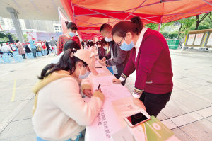 在招聘展台前，很多残疾人应聘。