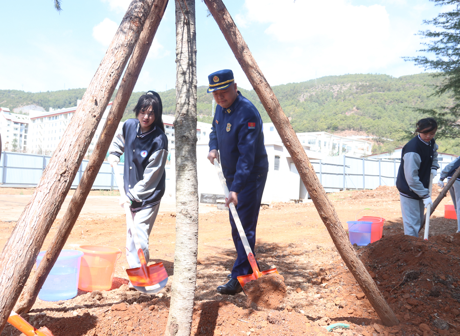 图为和学生共同植树。木晓东摄
