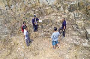 张世山（右三）在梅树村剖面一处岩石断层前给中国前寒武系省级地质自然保护区管护局的几个年轻人讲解（5月10日摄，无人机照片）